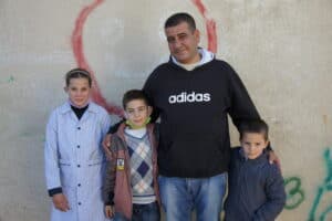 Family standing together against a graffiti wall, symbolizing hope and resilience.