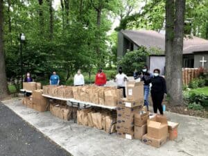 Volunteers assist community members at a food pantry during increased need amid the COVID‑19 pandemic.
