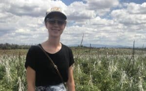 person wearing hat and sunglasses standing farmland