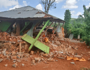 rural home in Haiti surrounded by rubble from earthquake destruction