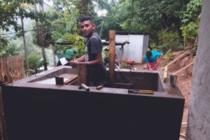 Young man working on a water tank installation in a rural area.