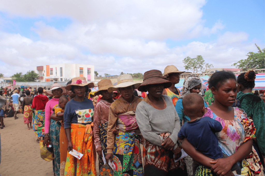 Madagascar community gathering with women and children in line.