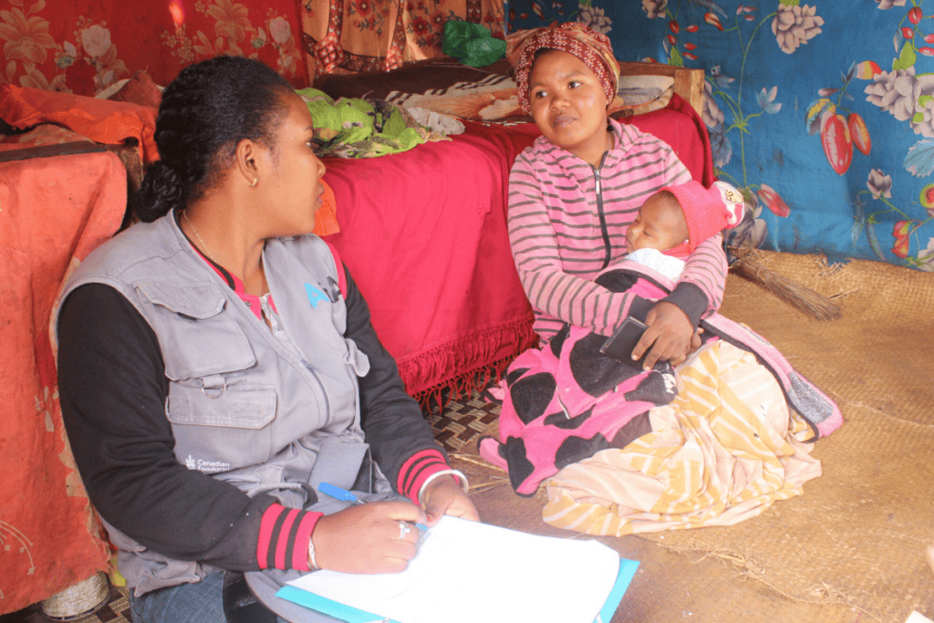 Women and child in Madagascar receiving community aid and support.