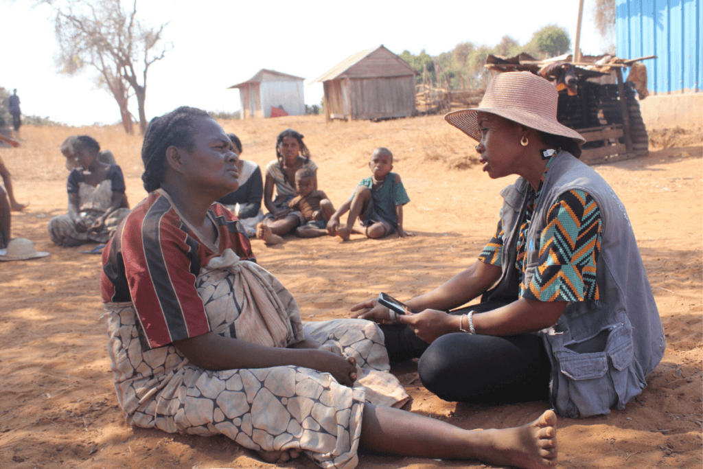 Women and children in Madagascar engaging in community support activities.