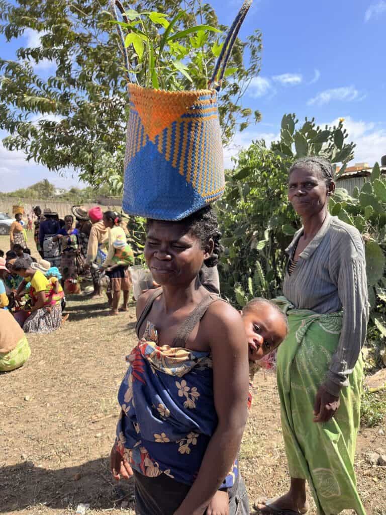 Madagascar community gathering with women and children outdoors.