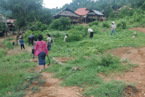 Community members working together on a farm in a rural area.