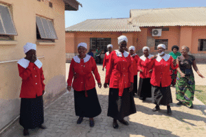 Group of women in red uniforms participating in community outreach.