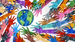 Colorful paper hands surrounding Earth symbolizing global unity and environmental care.