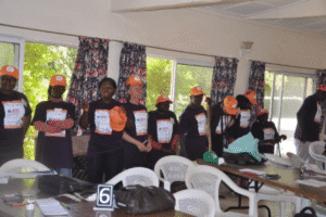 Group of volunteers wearing orange caps at community service event.
