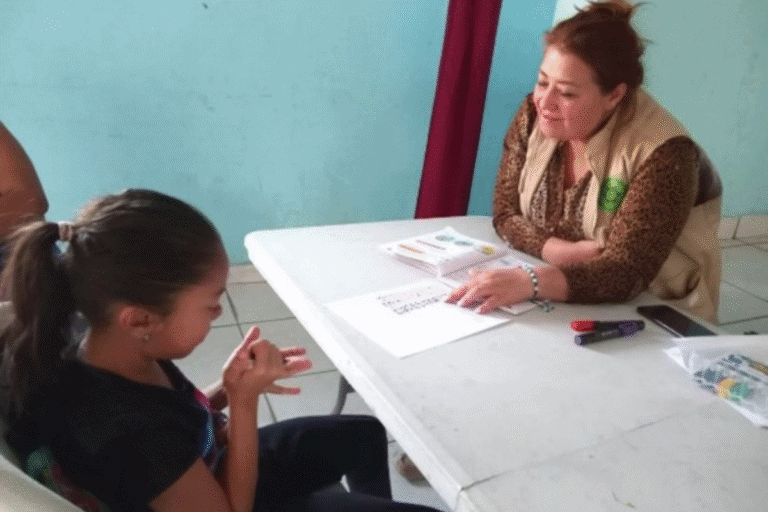 Woman and girl engaging in a community support discussion at a table.