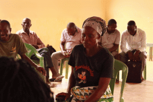 Women and men participating in a community meeting supported by World Renew.