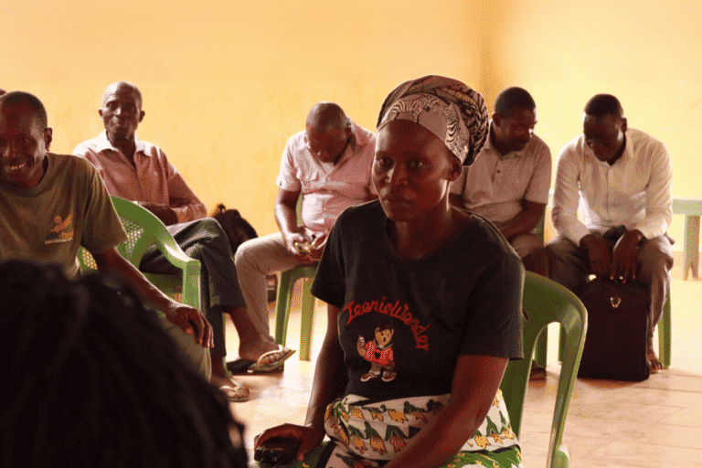Women and men participating in a community meeting supported by World Renew.