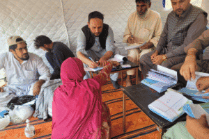 Group of people discussing aid programs in a community tent.