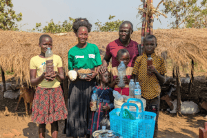 Community members with water bottles and supplies in rural Africa.