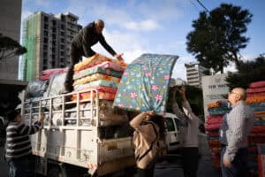 People distributing blankets and supplies in Lebanon for humanitarian aid.