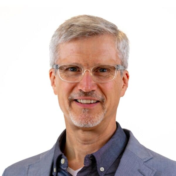 Smiling man in glasses and blue blazer representing World Renew.