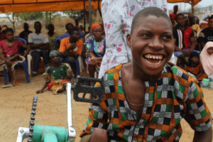 Happy young man with a prosthetic limb at community event in Africa.