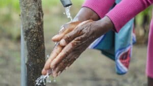 Person washing hands at a water tap in Ikurungu, Kenya.
