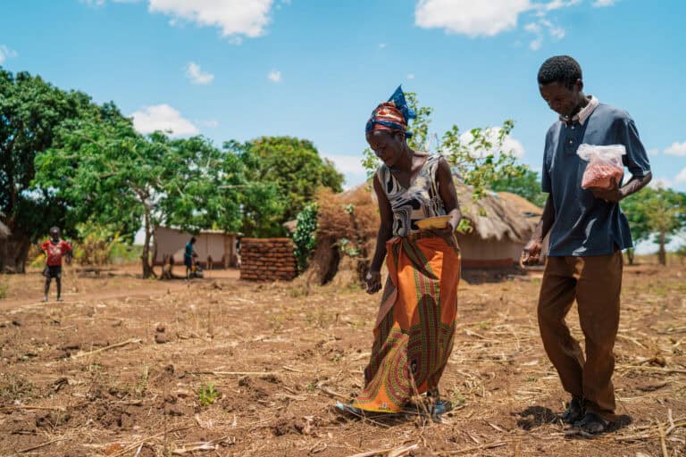 Local farmers planting seeds in a rural African community.