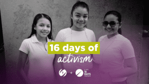 Three girls smiling at an activism event promoting gender equality.