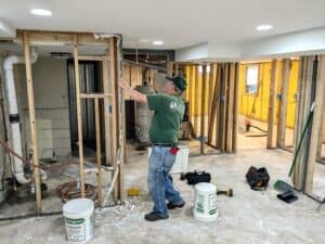 Worker repairing flood-damaged interior during recovery efforts in Iowa.