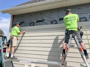 Volunteers repairing a house wall after flooding in Iowa.