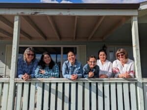 Group of diverse women smiling on a balcony for refugee support in Canada.
