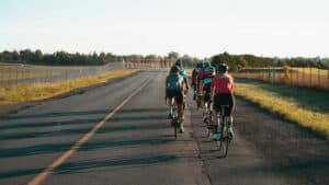 Cyclists riding together on a rural open road during daytime.