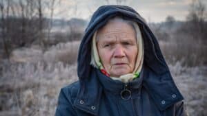 Ukrainian woman in winter clothing outdoors during conflict.