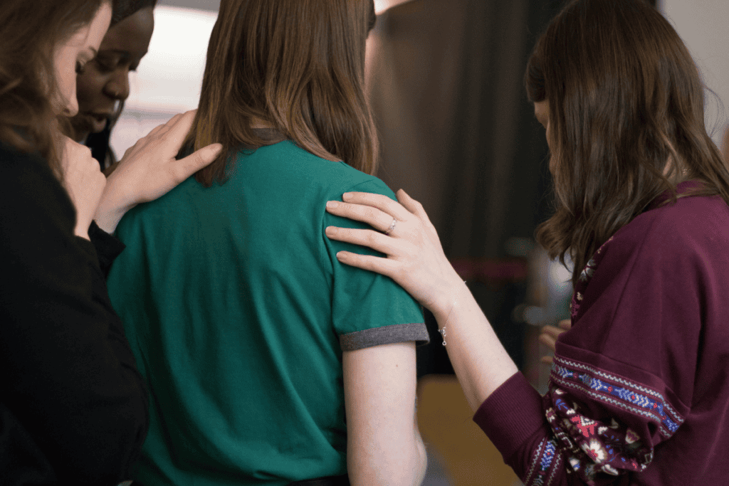 People praying and supporting each other in a church setting.