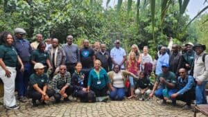 Conference participants gather outdoors during a field visit at an agricultural learning event.