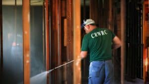 CRWRC volunteer works inside a damaged building during disaster recovery and rebuilding efforts.